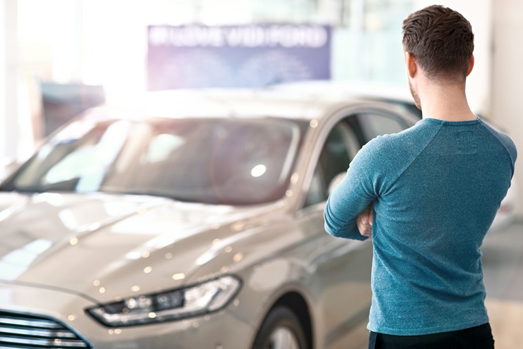 Young man looking at the new car